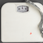 Bathroom scale with measuring tape symbolizing weight struggles before starting keto